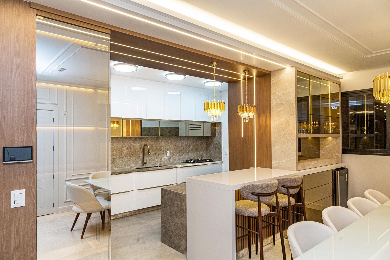 Cozinha planejada ampla integrada com bancada e banquetas