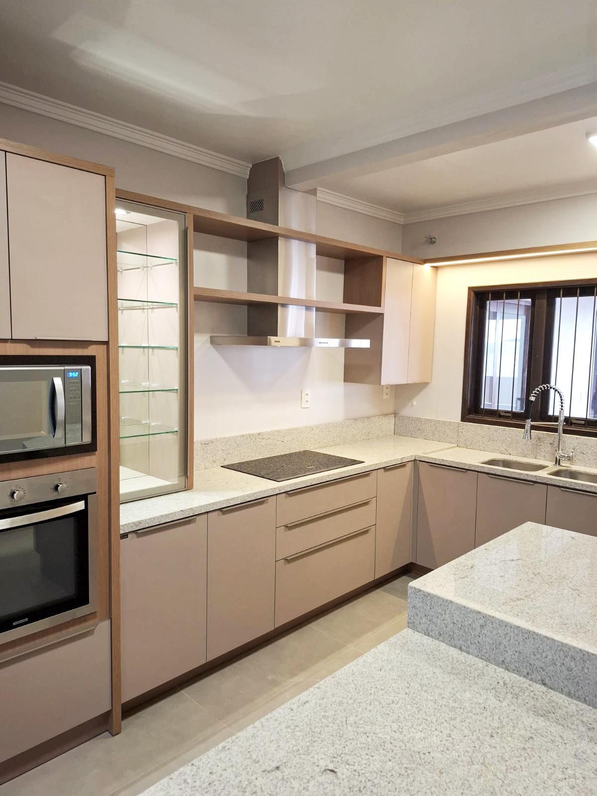 Cozinha planejada em MDF com armários em tom neutro e nichos com vidro