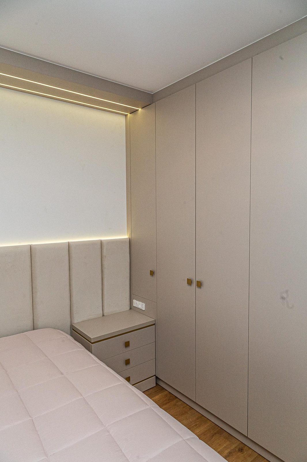 Quarto pequeno com roupeiro planejado do piso ao teto e cabeceira estofada